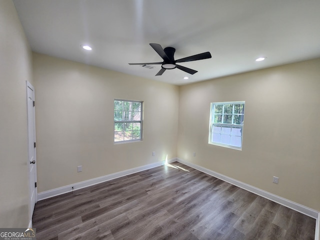 spare room featuring wood-type flooring, a wealth of natural light, and ceiling fan