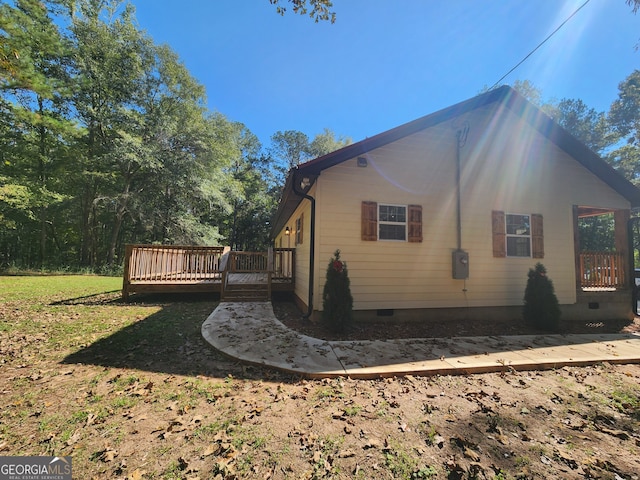 view of property exterior featuring a lawn and a wooden deck