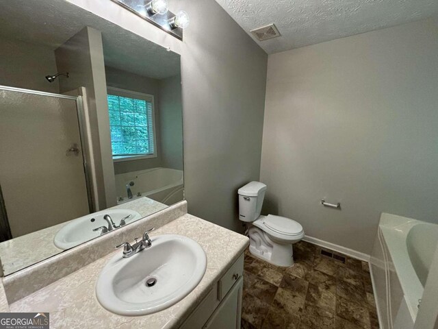 bathroom with a textured ceiling and shower with separate bathtub