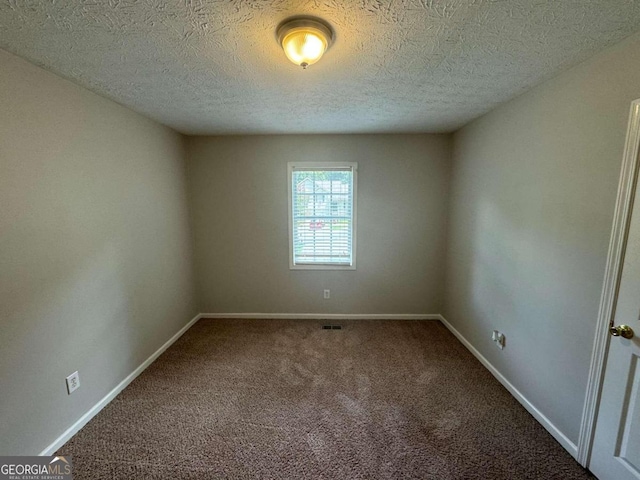 empty room featuring carpet floors and a textured ceiling