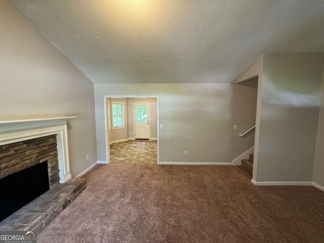 entryway featuring a textured ceiling, lofted ceiling, a healthy amount of sunlight, and dark colored carpet