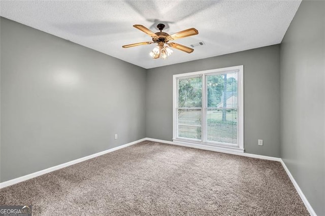 carpeted spare room with ceiling fan and a textured ceiling