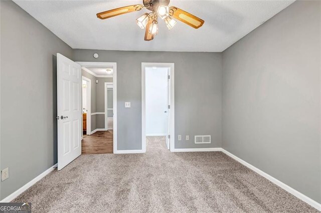 unfurnished bedroom with ceiling fan and light colored carpet