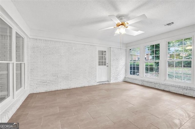 unfurnished sunroom featuring ceiling fan and a skylight