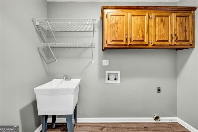 washroom featuring washer hookup, cabinets, hardwood / wood-style flooring, and electric dryer hookup