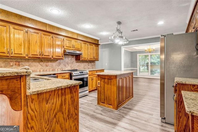 kitchen with light hardwood / wood-style flooring, stainless steel appliances, hanging light fixtures, ornamental molding, and a center island