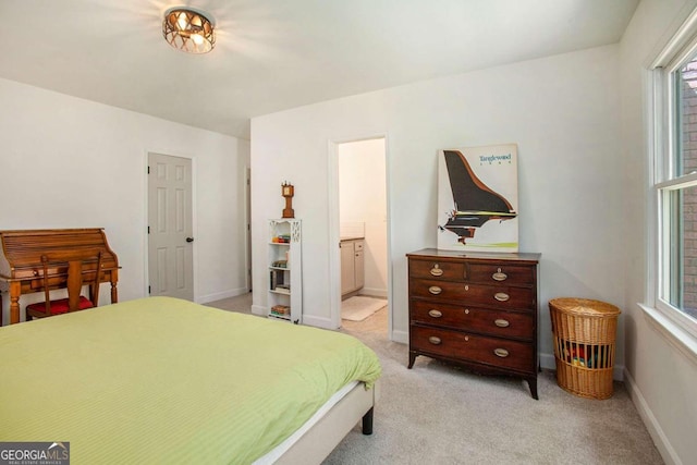 bedroom featuring light carpet and ensuite bath