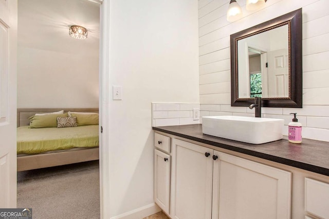 bathroom featuring wooden walls, vanity, and tasteful backsplash