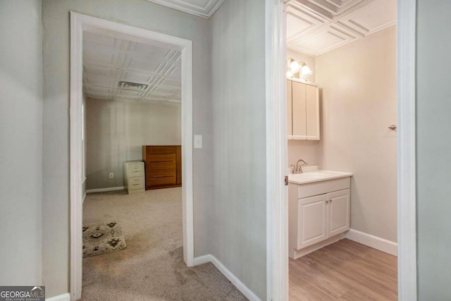 bathroom with crown molding, hardwood / wood-style flooring, and vanity