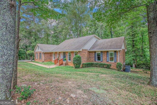 single story home featuring a front yard and central AC unit