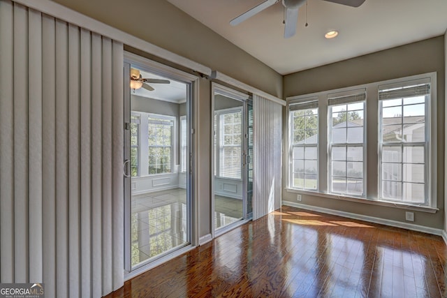 unfurnished sunroom featuring ceiling fan