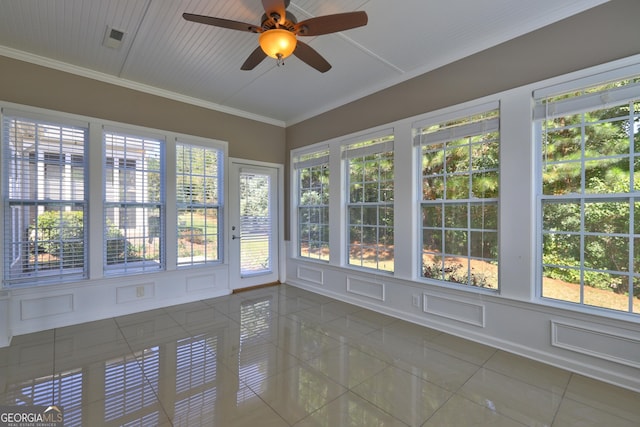 unfurnished sunroom featuring ceiling fan and a healthy amount of sunlight