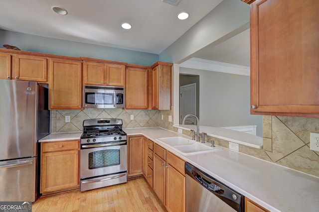 kitchen featuring backsplash, sink, ornamental molding, appliances with stainless steel finishes, and light hardwood / wood-style floors