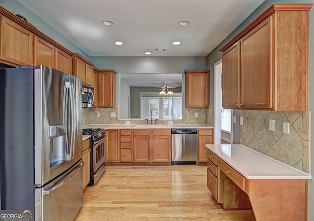 kitchen with backsplash, stainless steel appliances, sink, a notable chandelier, and light hardwood / wood-style floors