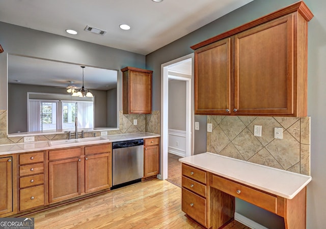 kitchen featuring tasteful backsplash, sink, decorative light fixtures, light hardwood / wood-style flooring, and dishwasher