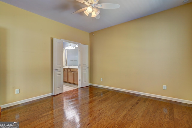 unfurnished bedroom featuring connected bathroom, ceiling fan, and light hardwood / wood-style flooring