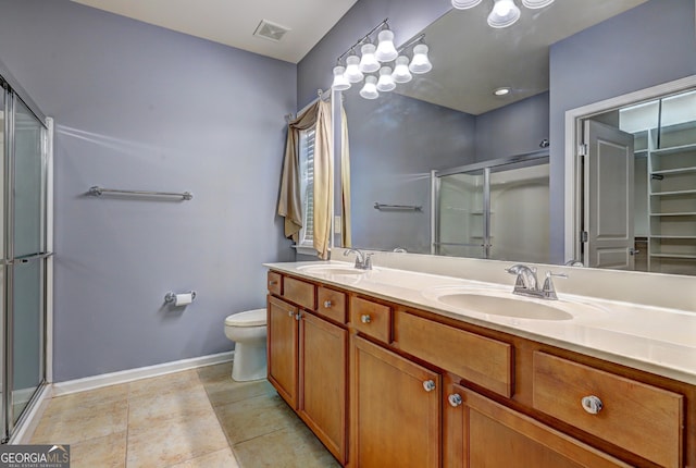 bathroom featuring tile patterned flooring, vanity, an enclosed shower, and toilet