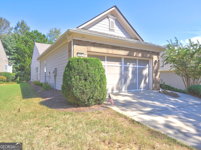 view of side of property featuring a garage and a lawn