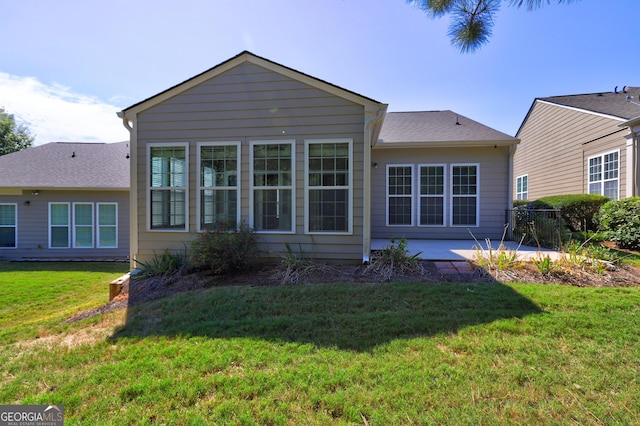 rear view of house featuring a yard and a patio