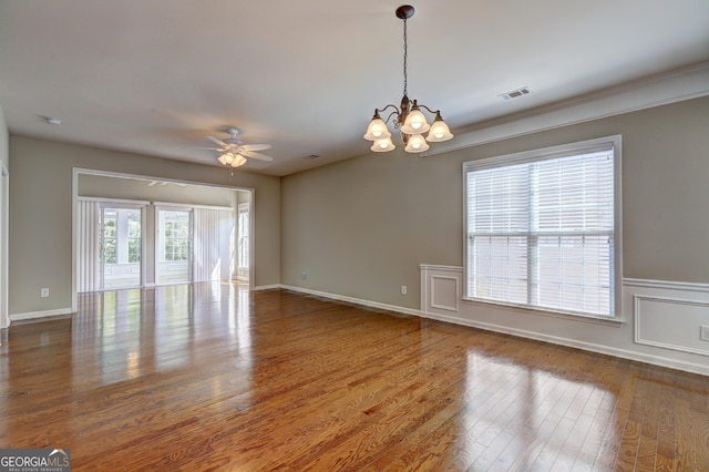 empty room featuring ceiling fan with notable chandelier and wood-type flooring