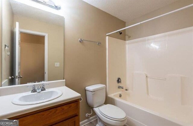 full bathroom featuring vanity, shower / bathtub combination, toilet, and a textured ceiling