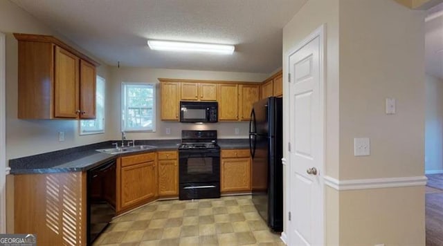 kitchen featuring black appliances, sink, and a textured ceiling