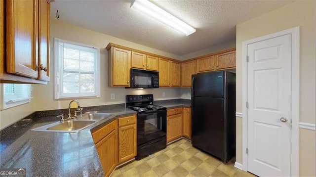 kitchen featuring black appliances, sink, and a textured ceiling