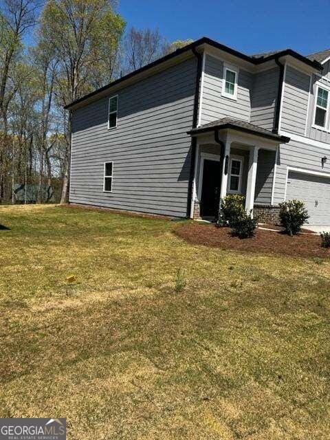 view of property exterior with a yard and a garage