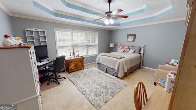 carpeted bedroom featuring crown molding, ceiling fan, and a tray ceiling