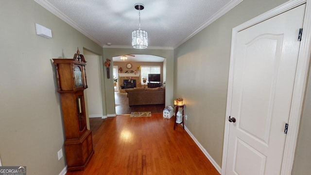 hall featuring hardwood / wood-style flooring, crown molding, and a textured ceiling