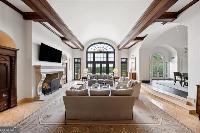 living room with light tile patterned flooring, ornamental molding, beam ceiling, french doors, and a high ceiling