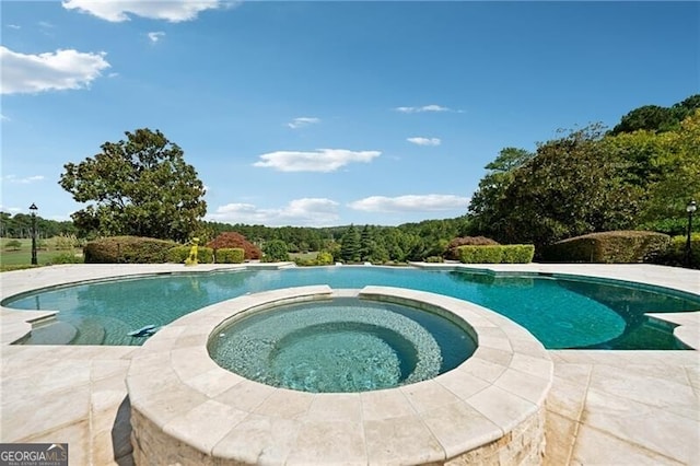 view of pool featuring an in ground hot tub