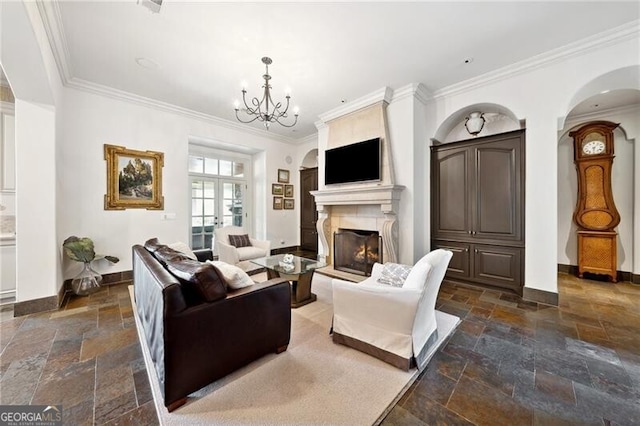 living room featuring a large fireplace, ornamental molding, and a notable chandelier