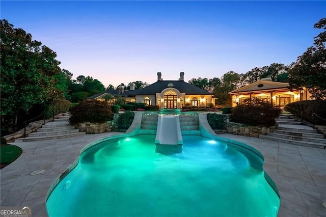 pool at dusk featuring a gazebo and a patio