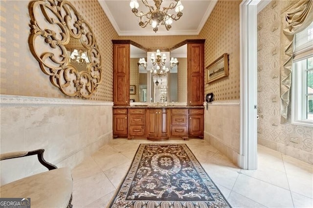 bathroom featuring an inviting chandelier, vanity, ornamental molding, and tile patterned floors