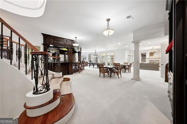 dining space with ornate columns, crown molding, and light carpet