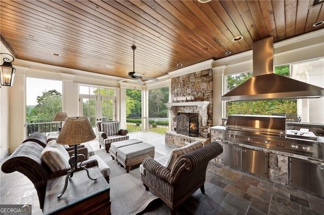 view of patio / terrace featuring ceiling fan, area for grilling, and a fireplace