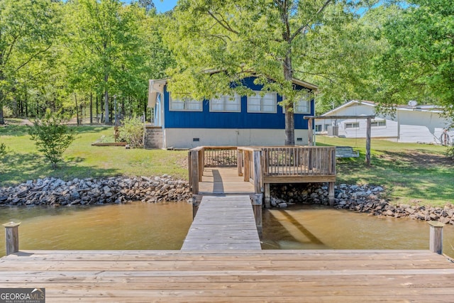 view of dock with a water view and a yard