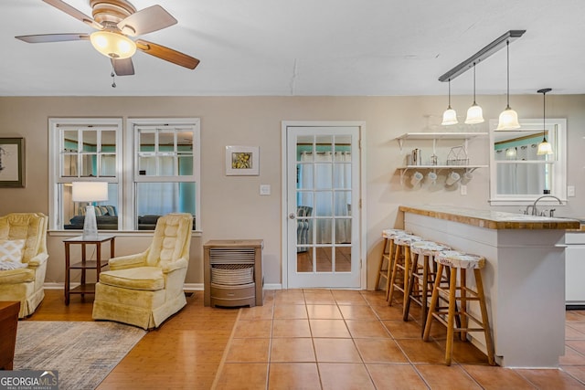 kitchen with pendant lighting, white cabinets, kitchen peninsula, light hardwood / wood-style flooring, and a breakfast bar