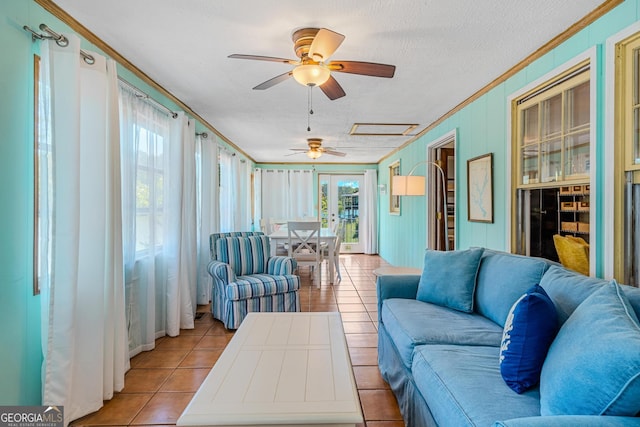 tiled living room with ceiling fan, a textured ceiling, and crown molding