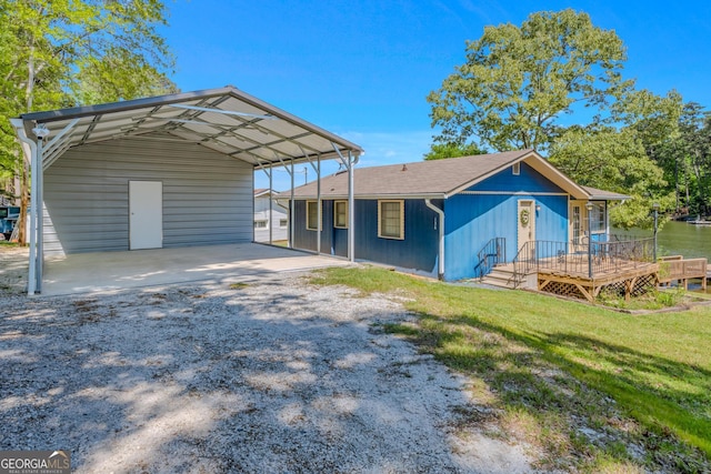 view of front of property featuring a carport, a wooden deck, and a front lawn