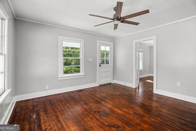 empty room featuring ceiling fan, crown molding, and dark wood-type flooring