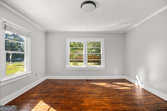 spare room with dark wood-type flooring, plenty of natural light, and crown molding