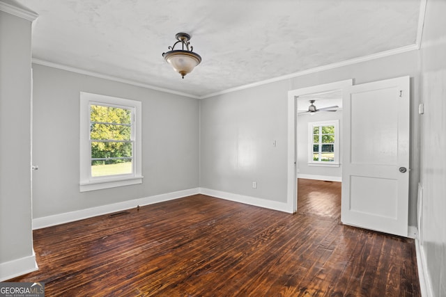 empty room with ornamental molding, dark hardwood / wood-style flooring, and a wealth of natural light