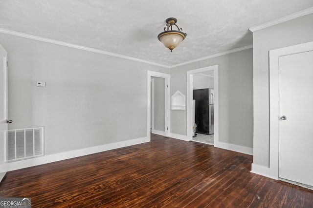 spare room featuring crown molding and dark wood-type flooring