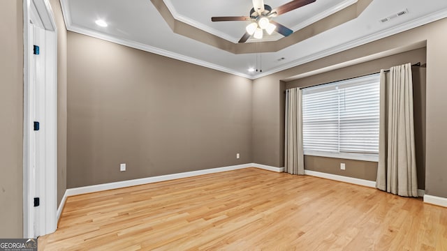 unfurnished room featuring a tray ceiling, light hardwood / wood-style flooring, ornamental molding, and ceiling fan