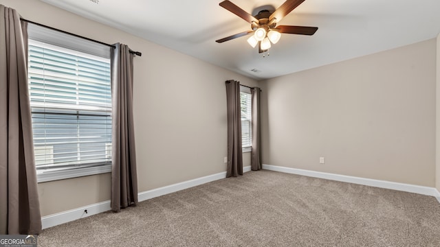 carpeted spare room featuring ceiling fan