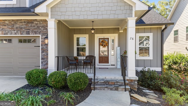 view of exterior entry with a garage and covered porch