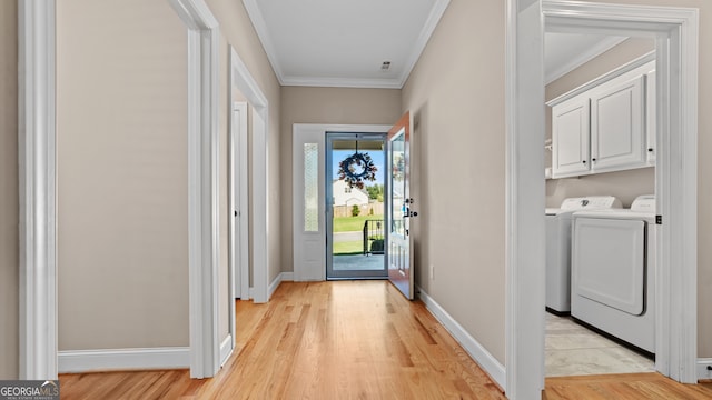 entryway featuring crown molding, light hardwood / wood-style flooring, and washing machine and dryer