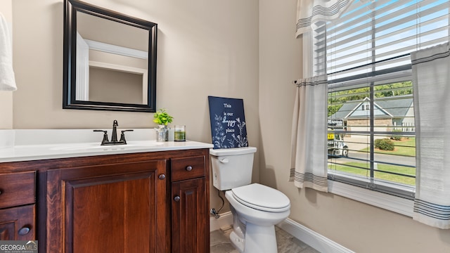 bathroom with vanity, a healthy amount of sunlight, and toilet